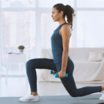 Sporty Hispanic girl doing lunges with dumbbells at home, empty space cardic yoga - healthtimes.me